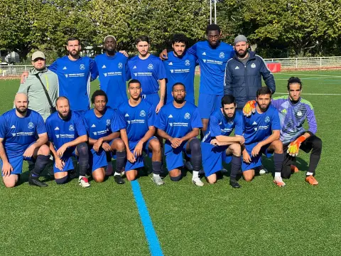 L’équipe seniors D2 du VFA en maillots bleus, accroupie et debout sur le terrain