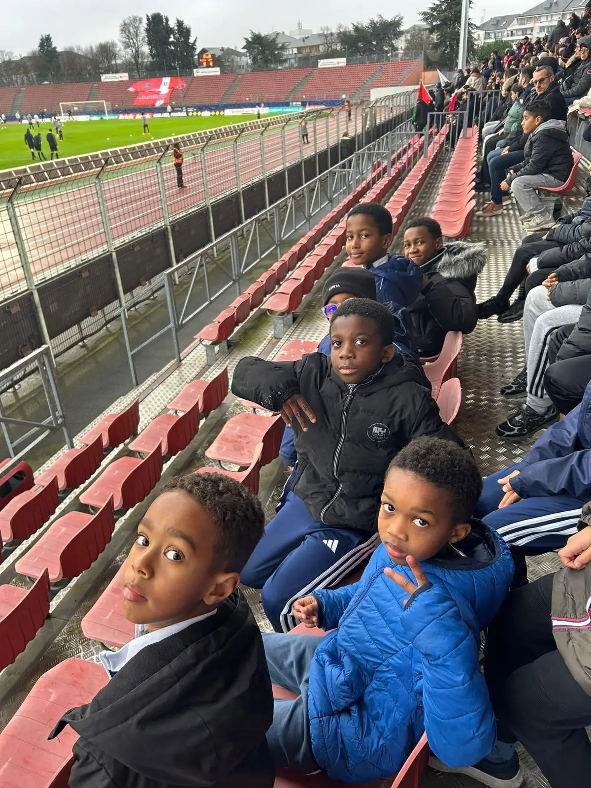Deux jeunes du VFA en tribune, la pelouse du stade en arrière-plan