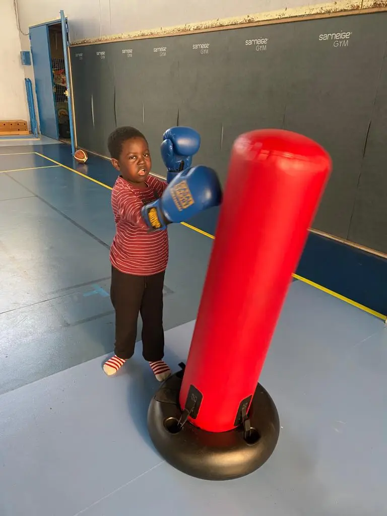 Un enfant frappe dans un punching-ball gonflable pendant la boxe éducative