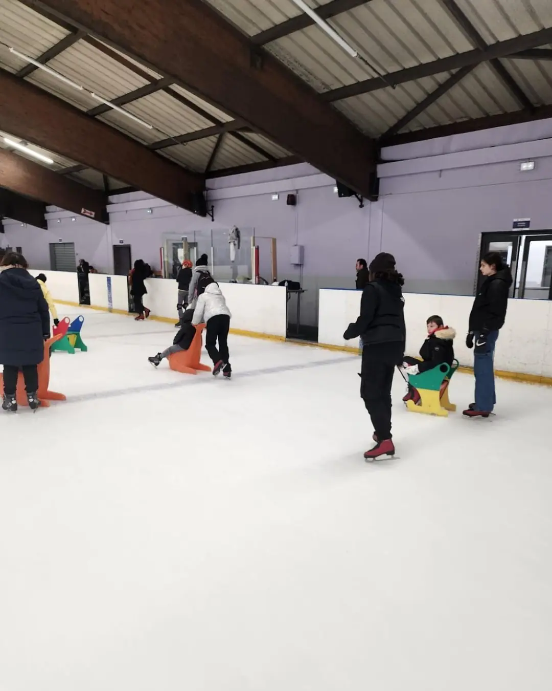 Enfants et accompagnateurs patinent sur la piste