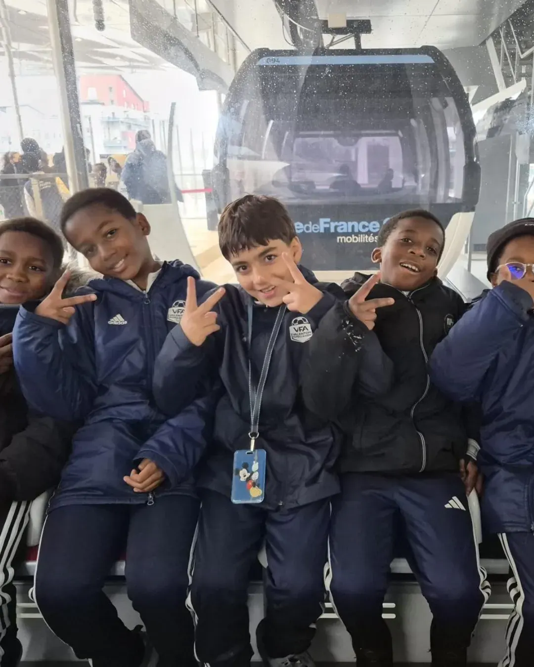 Les U9 et U10 du VFA font le signe de la victoire dans une cabine du téléphérique